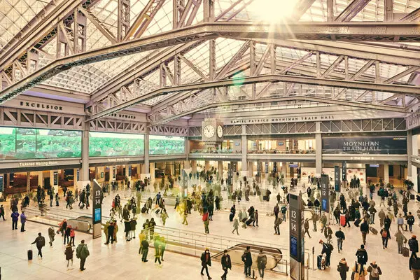 A multiple exposure consisting of 10 frames shows visitors and passengers moving through the new Moynihan Train Hall. 